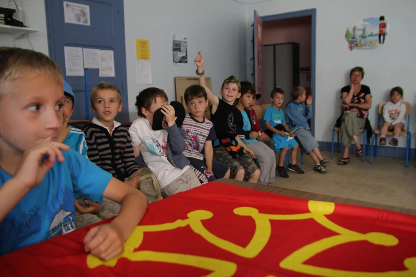 Des enfants en classe autour d'un drapeau occitan